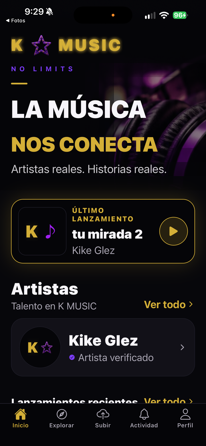 Pantalla de inicio de la aplicación K MUSIC en un iPhone, con el último lanzamiento, la sección de artistas y la barra de navegación.